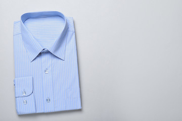 Stylish light blue shirt on white background, top view with space for text. Dry-cleaning service