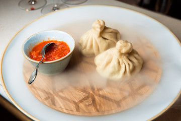 Juicy khinkali on a white plate.
