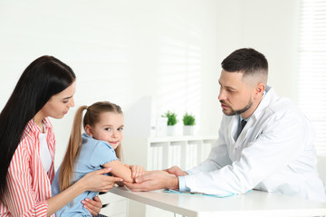 Little girl with mother visiting orthopedist at clinic