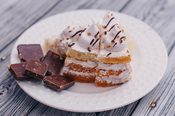 on a white plate chocolate with nuts and a piece of cake with white cream