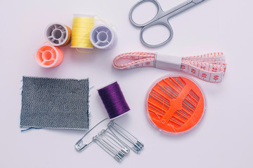 Sewing tools, thread, needles, scissors. Top view on a white background. Needlework.