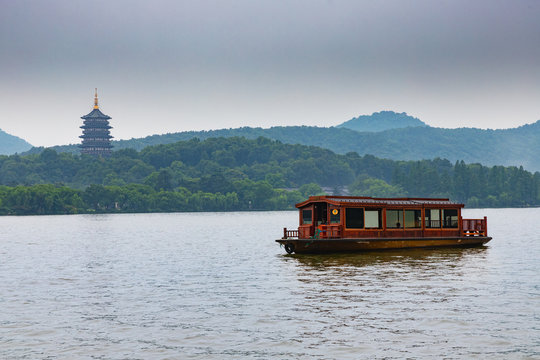 Boat cruising the West Lake in Hangzhou, China. Pagoda in the background