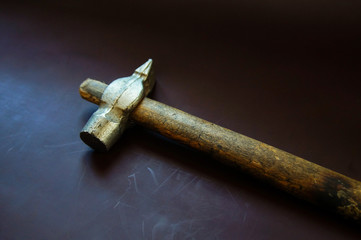 hammer in hand on brown leather
