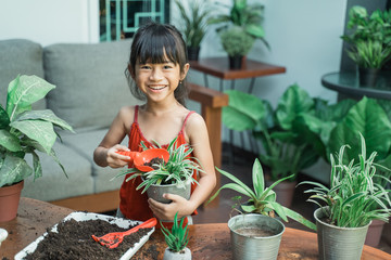 happy asian kid planting and gardening activity at home by herself