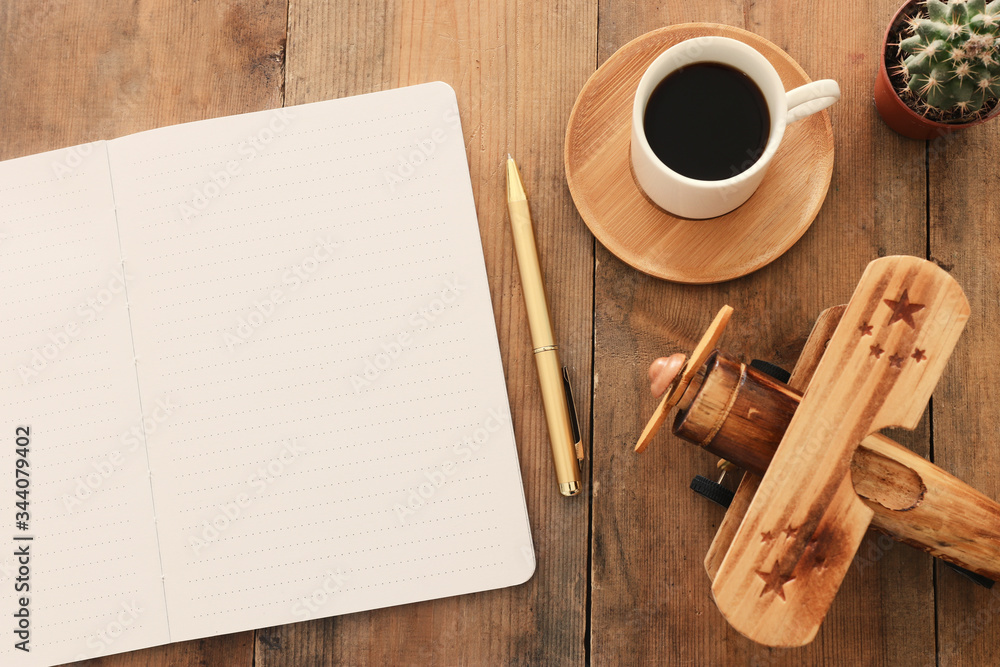 Fototapete top view image of open notebook with blank pages next to cup of coffee on wooden table. ready for ad