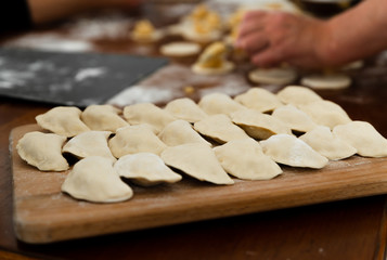 National dish,raw dumplings lie on a wooden board,homemade cooking dumplings with meat,beautifully arranged dumplings