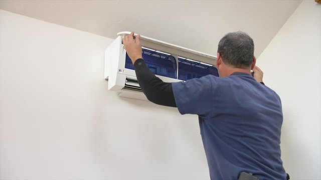 Man opening an air conditioning unit