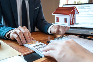 Real estate agent are presenting home loan and sending keys to customer after signing contract to buy house with approved property application form, Insurance Home concept