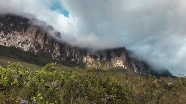 Low angle view of the Roraima wall mountain range with an active cloud movement. Daytime, bright.