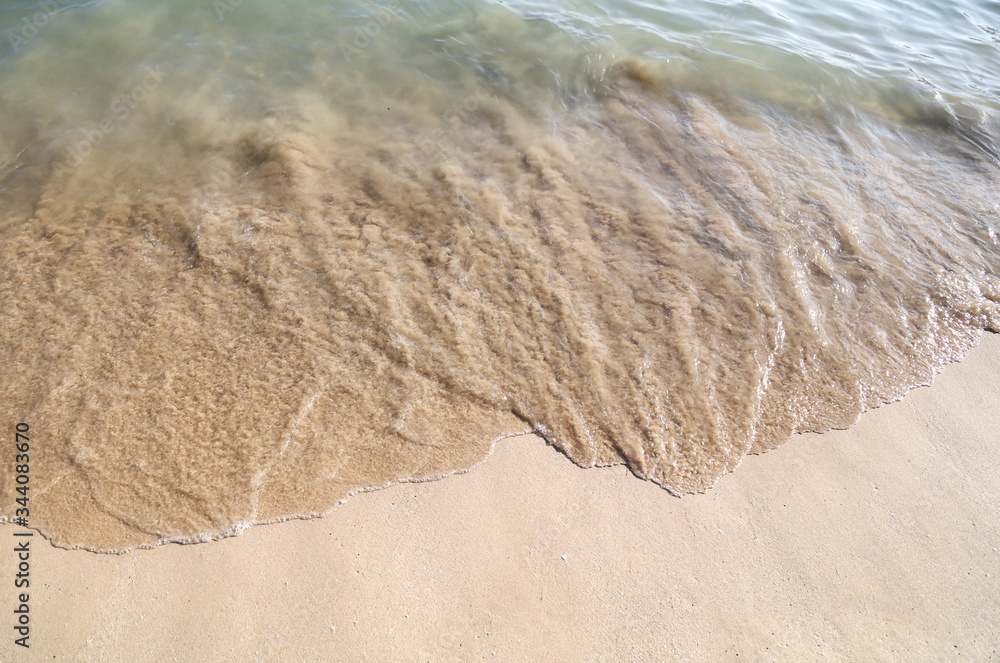 Sticker Sand washed with water from the sea.