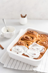 Cinnamon rolls or cinnabons with cream sauce on white background. Homemade buns. Bakery menu, recipe, pastry, cook book. Hygge. Side view