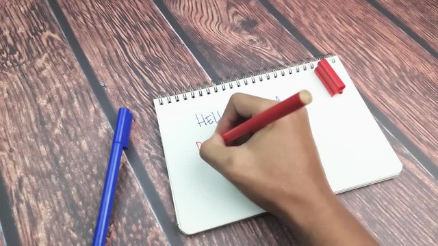 A man writen Hello I am a Repeat Customer on wooden table. 4k Resolution
