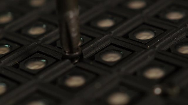 Manually unscrewing and removing screw with hand and screwdriver. Macro.