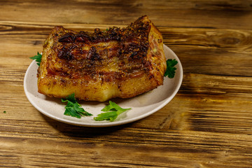 Baked pork belly in a plate on wooden table