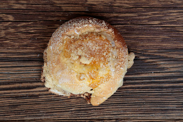 Top view, close-up of a fresh homemade bun with marmalade, fruit mousse. Cake on a wooden, brown, rustic table.