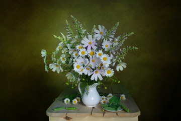 Bouquet of white daisies and pink bells lying on the table on a white background