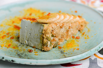 A piece of cream cake with bananas served on a blue plate. Sweet sugary cream dessert. Fruit cake pie.