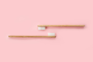 Two bamboo toothbrushes on pink background. Dental and healthcare concept. Top view, flat lay. - 344088209