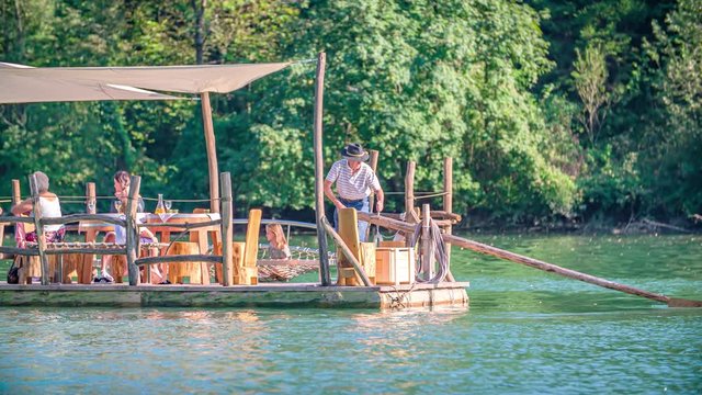 Slow motion shot of a raftsman rowing with a long wooden oar in a traditional Slovenian raft