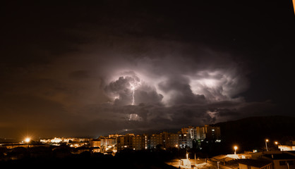 Fototapeta premium lightning and thunderstorm over the city of iglesias city in southern Sardinia