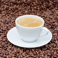 white coffee cup with coffee beans