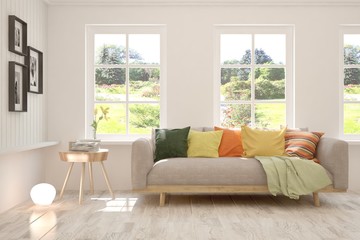 White living room with sofa and summer landscape in window. Scandinavian interior design. 3D illustration