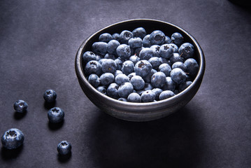 Fresh blueberries in black ceramic bowl