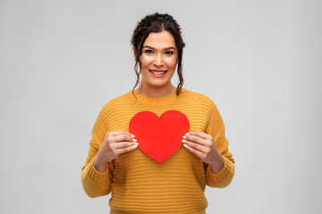 love, valentines day and charity concept - portrait of happy smiling young woman with red heart over grey background