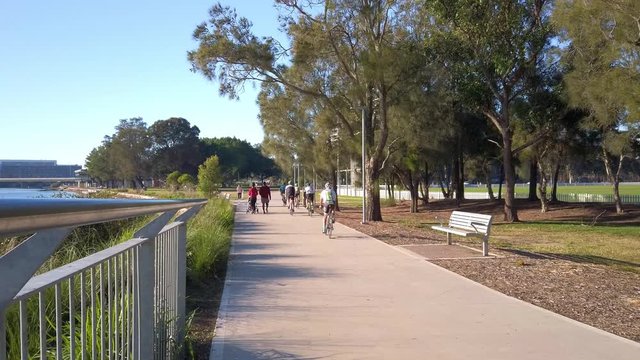People are walking and riding bicycle by the river in the public park during Coronavirus outbreak lockdown. Sydney, Australia