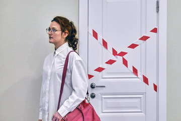 A woman leaves a closed office. Problems with work and closing companies due to the disease epidemic