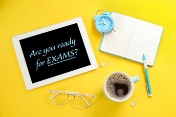 Modern tablet with phrase ARE YOU READY FOR EXAMS on yellow background, flat lay