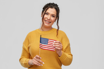 people concept - happy smiling young woman with pierced nose with flag of united states of america...
