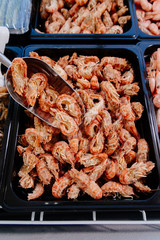 Frozen prawns in a supermarket refrigerated display case. Frozen seafood. Shrimp in the freezer on the window.