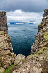 Deep ravine near the ocean with islands in the background