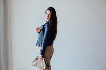 Beautiful fashionable oriental brunette woman in black leather jacket