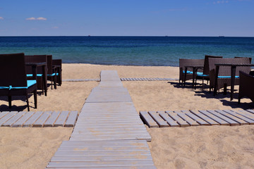 Fototapeta na wymiartables and wooden walkway along the food beach to the sea