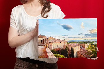 Person holds a photo canvas print on red background