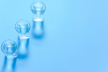 Glasses of water on blue. Close up. Copy space. Water balance for healthy and detox.