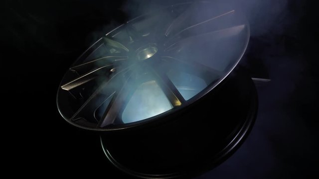 Metal alloy wheels for vehicle, auto. Luxury design. Modern new equipment for car in dark background with smoke, fume. Expensive bright metal aluminium or magnesium disks made of carbon or chrome lie