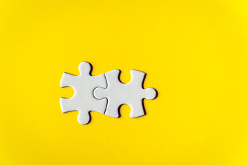 Obraz premium Puzzle pieces on yellow background. Double piece flat puzzle. Business background. Copy space for text, top view.