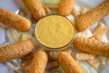 Deliciosos palitos de mozzarella y queso suizo, con la sugerente salsa de mostaza con miel. Palitos de queso con salsa y cebolla.