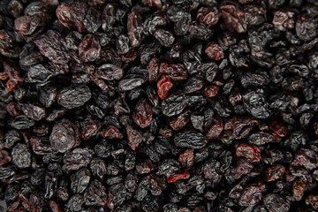 Raisins texture background. Heap of dried red grapes