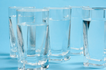 glasses with water on blue background. clean water concept