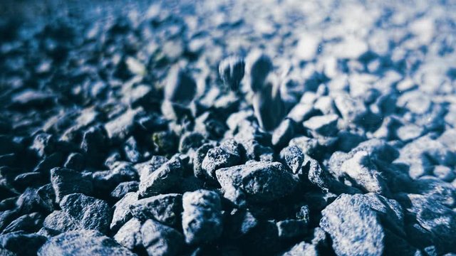 Close-up of black coal at plant. Stock footage. Black stones fall on pile of black raw materials. Black raw materials for additives in processing plant