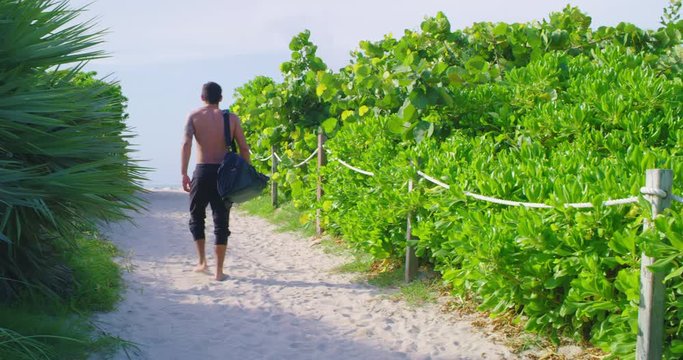 Man walking to beach with gym bag