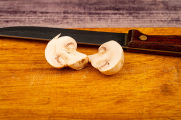 Halves of a cut mushroom on a wooden background. Close up.