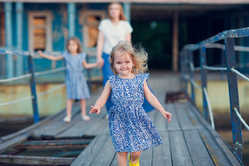mom and kids in blue clothes standing old bridge