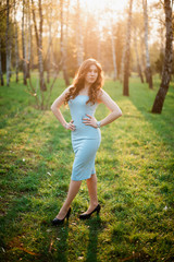 Beautiful young girl in a blue dress in a spring park