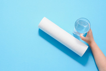 A glass of water on the background of filter cartridges