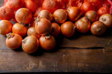 Fresh ripe onions on wood background.